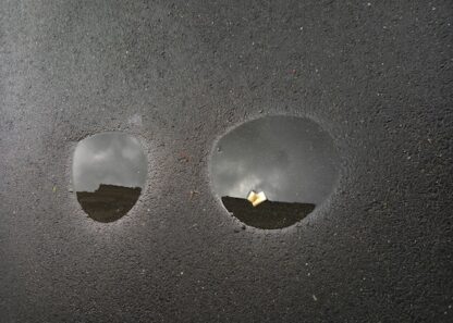 Deux petites flaques sur le trottoir après la pluie à Rennes quai de Richemont